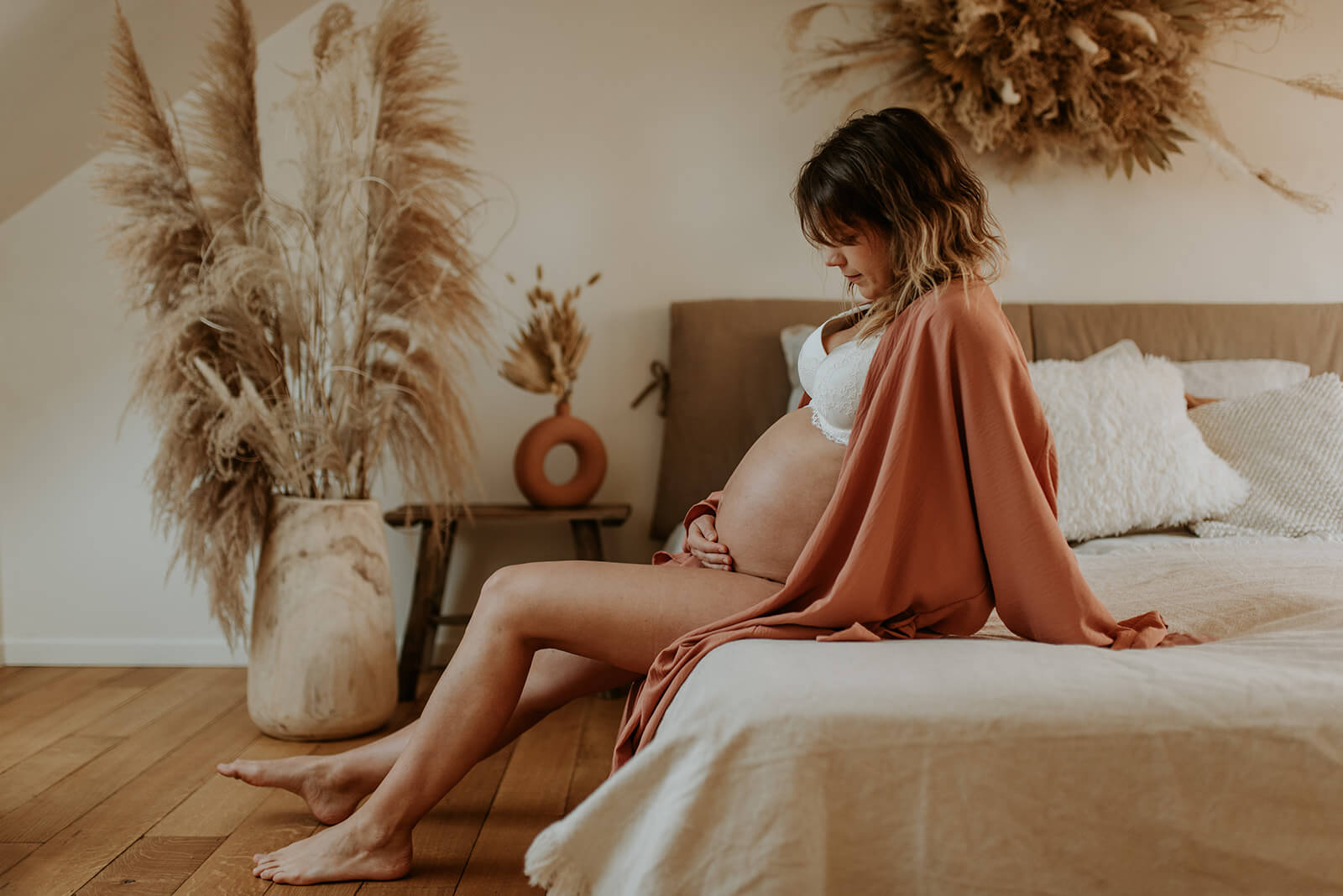 zwangere vrouw zit op bed in mooie kamer